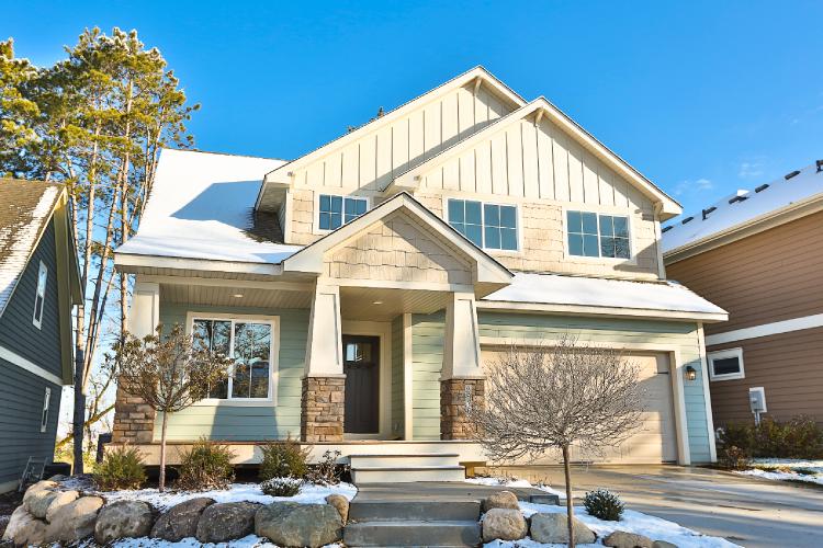 (This home is clad in HardiePlank® lap siding in minty green with HardiePanel® vertical siding and HardieShingle® siding in a creamy neutral. The varieties of siding styles on this quaint, snow-dusted home make it feel cozy and comfortable.)