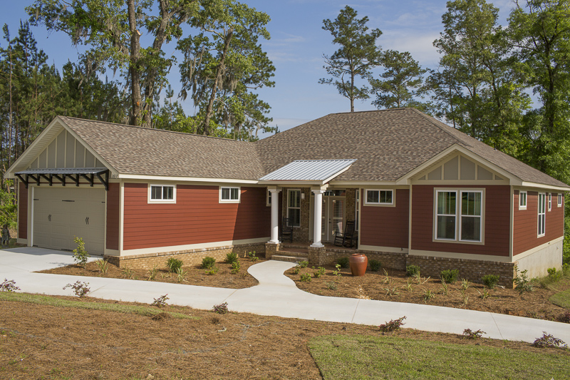 Colors are critical when creating a sense of coziness, and warm hues are the way to go. This home is clad in HardiePlank lap siding in Countrylane Red with the HardiePanel vertical siding in Monterey Taupe and HardieTrim® boards in Sandstone Beige. The warm red paired with the soft neutrals provides an inviting farmhouse feel. 