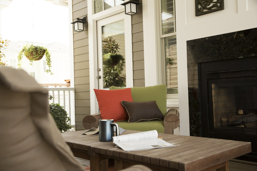 As you design your outdoor areas, try to create spaces that exude informal tranquility, too. This home is clad in HardiePlank lap siding in Timber Bark, and makes an ideal backdrop for this cozy porch space. The comfy furniture, the reading material, a warm cup of coffee, a fireplace and greenery—all ways to make a space feel friendly. 