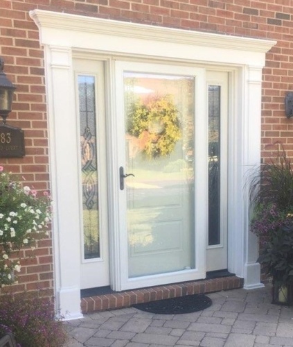 a white front door with storm door and surrounding sidelites